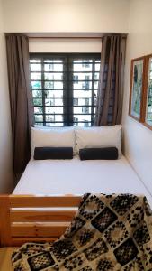 - une chambre avec un grand lit et une fenêtre dans l'établissement Mireya's Studio Condo at Goshen Towers - Session Road, à Baguio
