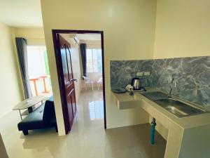 龜島的住宿－布春旅舍，厨房配有水槽和带镜子的台面