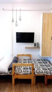- une chambre avec 2 lits et une télévision murale dans l'établissement Mireya's Studio Condo at Goshen Towers - Session Road, à Baguio
