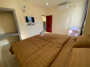 um quarto com uma cama grande e uma televisão em Budchui Guesthouse em Ko Tao