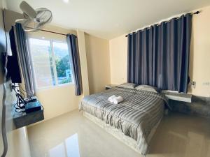 a bedroom with a bed and a large window at Budchui Guesthouse in Koh Tao