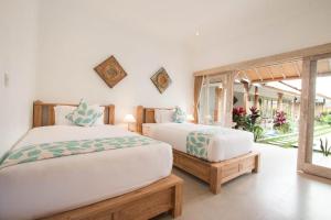 ein Schlafzimmer mit zwei Betten und einem großen Fenster in der Unterkunft Peaceful Haven 6BR Private Pool Villa in Canggu in Canggu + 17 Fotos