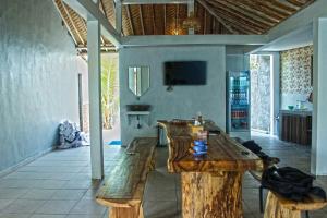 ein Wohnzimmer mit einem Holztisch und Bänken in der Unterkunft Peaceful Haven 6BR Private Pool Villa in Canggu in Canggu