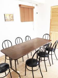 een houten tafel met zwarte stoelen eromheen bij Terraza Tlalpan-Acoxpa in Mexico-Stad