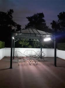 a gazebo with two chairs and a table at night at Terraza Tlalpan-Acoxpa in Mexico City