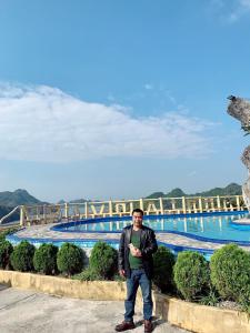 um homem parado em frente a uma piscina em Cat Ba Mountain View em Ilha de Cát Bà