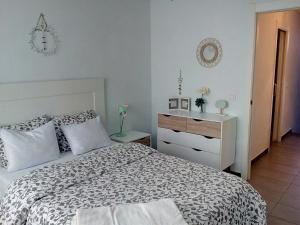 カルボネラスにあるTríplex Faroのベッドルーム1室(ベッド1台、ドレッサー付)