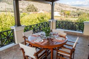 a wooden table and chairs on a porch with a view at Galaxidi Mansion in Galaxidhion