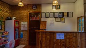 een restaurant met een koelkast en een bar met alleen een bakbord bij Southside Tourist Inn in Loboc