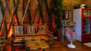 a room with two chairs and a fan and a refrigerator at Southside Tourist Inn in Loboc