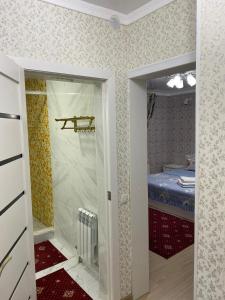 a small room with a door to a bedroom at Гостиница АСКАР in Shymkent