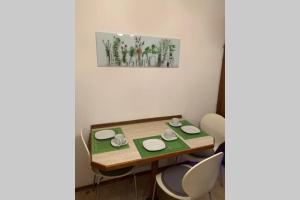 a dining room table with chairs and a painting on the wall at Appartement Zauner in Oberndorf bei Salzburg