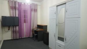 a room with a desk and a tv and some curtains at Houria App Sidi Bernoussi in Casablanca