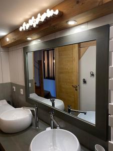 een badkamer met 2 wastafels en een grote spiegel bij La Grange Auguste avec Sauna Jacuzzi in Vénosc