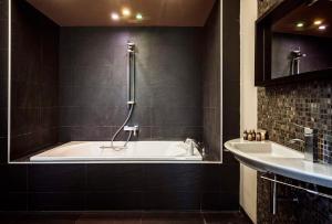 a bathroom with a bath tub and a sink at Hostal La Plaça in Erill la Vall