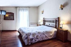 a bedroom with a large bed and a window at Hostal La Plaça in Erill la Vall