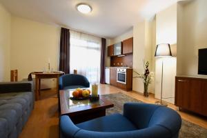 a living room with a couch and a table with fruit at Dolomiti Apartments in Bansko