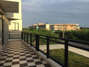 balcón con barandilla negra y suelo a cuadros en Destination Inn en Magong