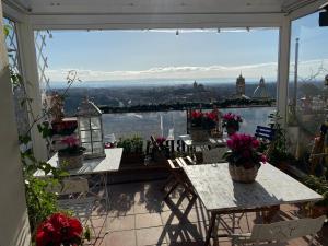 a balcony with tables and chairs and a view of the city at B&B TreMetriSoprailCielo Camere con vista terrazzo panoramico in Caltagirone