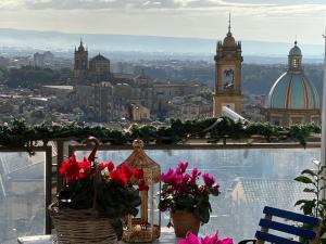 a view of a city from a balcony with flowers at B&B TreMetriSoprailCielo Camere con vista terrazzo panoramico in Caltagirone