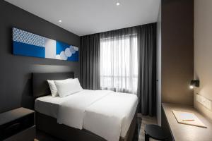 a hotel room with a bed and a desk at Komune Living in Kuala Lumpur