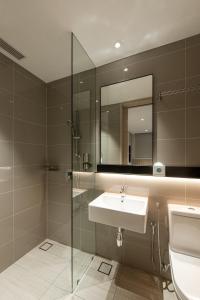 a bathroom with a tub, sink and mirror at Komune Living in Kuala Lumpur