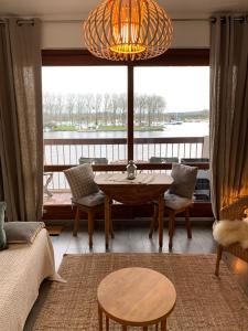 a living room with a table and a large window at Appart 24 avec vue Port in Ouistreham