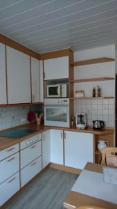 a kitchen with white cabinets and white appliances at Ferienwohnung Niemeyer in Oldenburg