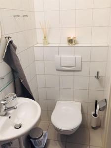 a white bathroom with a toilet and a sink at Apartment Marktplatz in Basel
