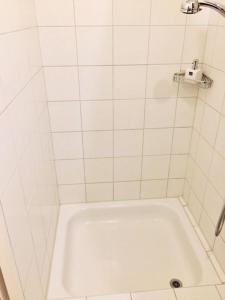 a white tiled bathroom with a bath tub at Apartment Marktplatz in Basel