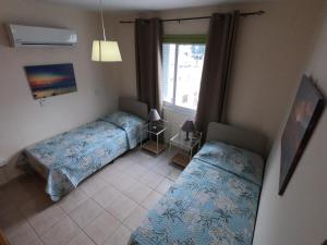 1 dormitorio con 2 camas y ventana en Amelia Two Bedroom Apartment - 201 en Pafos