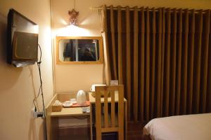 パタンにあるHotel Siraajのベッド、テーブル、テレビが備わる客室です。