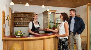 a group of three people standing around a counter at Genusshotel Hohenbogen in Neukirchen beim Heiligen Blut