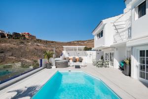a villa with a swimming pool and a house at Sea view villa San Agustin vista Claveles in San Agustin