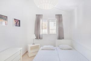 a white bedroom with a bed and a window at Sea view villa San Agustin vista Claveles in San Agustin