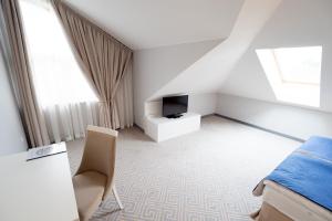 Televízia a/alebo spoločenská miestnosť v ubytovaní Hotel Aleksandria