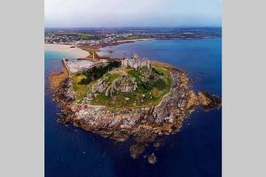 an island in the ocean with a castle on it at Honeysuckle Cottage by The Sea in Mousehole