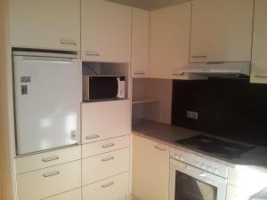 a kitchen with white cabinets and a microwave at Wohnen mit Panoramablick in Gramastetten