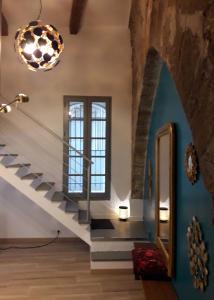 a hallway with stairs and a large window at CENTRE HISTORIQUE T3 DUPLEX PARKING Gratuit in Béziers