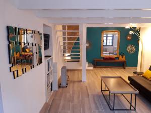 a living room with a couch and a table at CENTRE HISTORIQUE T3 DUPLEX PARKING Gratuit in Béziers