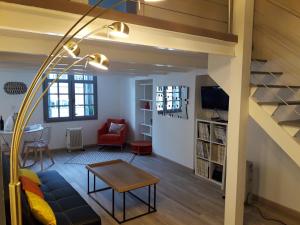 een woonkamer met een bank en een tafel bij CENTRE HISTORIQUE T3 DUPLEX PARKING Gratuit in Béziers