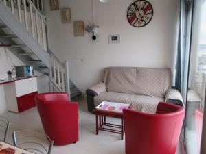 フロンティニャンにあるAppartement Grand Calypsoのリビングルーム(ソファ、椅子、時計付)