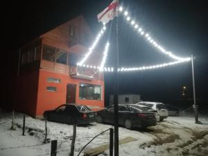 un edificio con auto parcheggiate in un parcheggio di notte di family hotel Mtamta a Gudauri