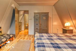 Noszvaj Cabin في نوسفاج: غرفة نوم مع سرير وخزانة