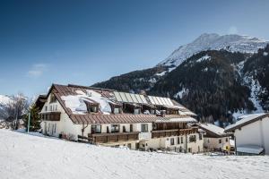 a building on top of a snow covered mountain at Hotel Sonnenheim in Sankt Anton am Arlberg