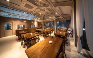 a restaurant with wooden tables and chairs and windows at Centro Hotel in Chilgok