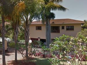 a house with palm trees in front of a yard at Stesh Margate Holiday House 12 Sleeper in Margate