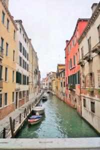 a canal in a city with two boats in the water at New central and spacious in Venice