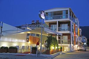 a building with a clock in front of it at Çözel Sare Hotel in Güzelçamlı