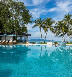 a swimming pool with palm trees and a building at Samui Palm Beach Resort - Lead by Celes Samui in Bophut